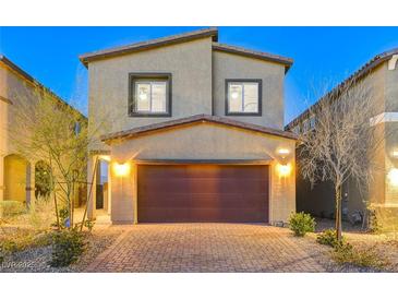 Inviting two-story home featuring a brick driveway, two-car garage, and desert landscaping at 5236 Sunstone Mesa Dr, Las Vegas, NV 89166