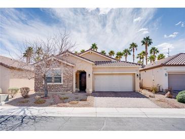 Charming single-story home featuring a stone facade, well-kept landscaping, and a two-car garage at 609 Viale Machiavelli Ln, Henderson, NV 89011