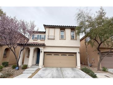 Charming two-story home featuring a tan stucco facade, a 2-car garage, and a red tile roof at 7735 Pista Way, Las Vegas, NV 89179