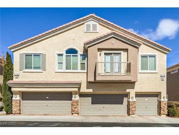 Inviting multi-level townhome with three-car garage, balcony, and neutral-toned stucco exterior at 8798 Tom Noon Ave # 103, Las Vegas, NV 89178