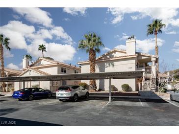 Well-maintained condo complex with mature palm trees and assigned covered parking at 1333 Pinto Rock Ln # 202, Las Vegas, NV 89128