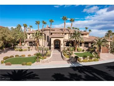 Elegant home exterior boasts a grand entrance, beautiful landscaping, and multiple palm trees at 2540 Red Arrow Dr, Las Vegas, NV 89135