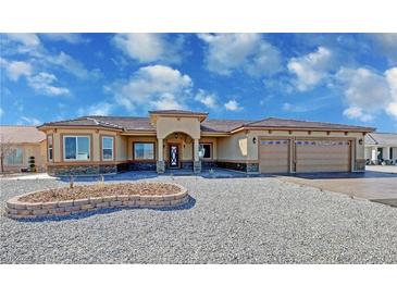 Beautiful single-story home with stucco exterior, stone accents, three-car garage, and desert landscaping at 3080 S Prairie Ave, Pahrump, NV 89048