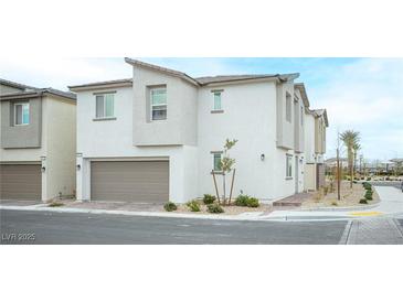 Two-story home features neutral stucco, an attached garage, and low-maintenance landscaping at 6913 Evening Orchid St, North Las Vegas, NV 89086