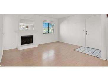 Bright living room featuring a fireplace, large window, and a neutral color scheme at 1701 E Katie Ave # 21, Las Vegas, NV 89119