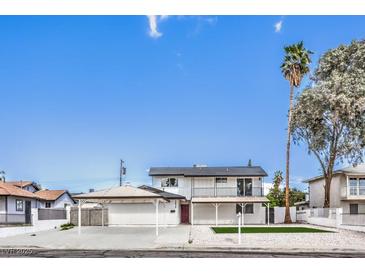 Charming two-story home with a covered parking area, balcony, a small lawn, and desert landscaping at 2834 Natalie Ave, Las Vegas, NV 89121