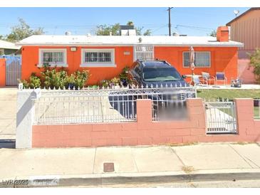 Charming single-story home featuring a vibrant orange exterior and well-manicured front yard at 4694 Meredith Ave, Las Vegas, NV 89121