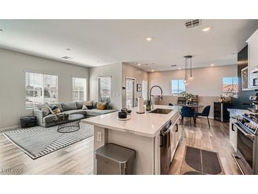 Open-concept living room features a modern kitchen with stainless steel appliances and a cozy living area at 524 Teovani St # 826, Henderson, NV 89052