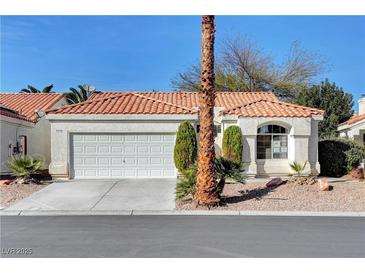 Charming single-story home featuring a red tile roof, two-car garage, and desert landscaping at 7772 Buckwood Ct, Las Vegas, NV 89149