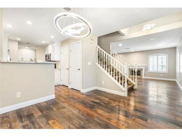 Inviting living room featuring wood floors, modern lighting, and staircase access to upper level at 8224 Crystal Star Ct, Las Vegas, NV 89145