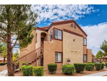 Charming two-story condo with landscaped yard and staircase leading to the front door at 9580 W Reno Ave # 211, Las Vegas, NV 89148