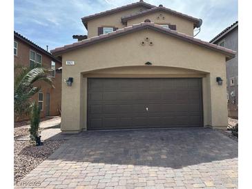 Beige two-story home featuring a brown two-car garage and a paved driveway at 961 Spiracle Ave, Henderson, NV 89002