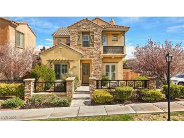 Charming two-story home showcasing stone accents, a quaint balcony, and a meticulously landscaped front yard at 11298 Merado Peak Dr, Las Vegas, NV 89135