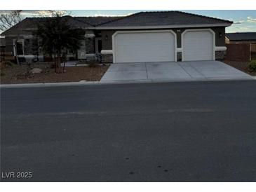 Charming single-story home featuring a spacious three-car garage and well-manicured front yard at 170 Magnolia Blvd, Pahrump, NV 89048