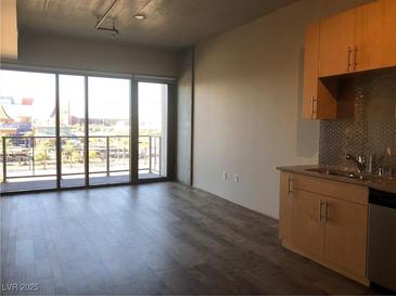 Bright living room featuring wood floors, sliding glass doors and a balcony with city views at 353 E Bonneville Ave # 621, Las Vegas, NV 89101