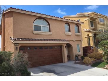 Two-story stucco home with a brown roof, arched windows, and a two-car garage at 6007 Sonoma Station Ave, Las Vegas, NV 89139