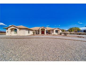 Expansive single-story home with a gravel driveway and well-maintained desert landscaping at 660 Indian Rd, Pahrump, NV 89048