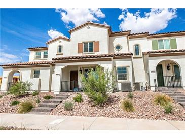 Beautiful townhouse with a stucco exterior, tile roof, and desert landscaping on a sunny day at 795 Pickled Pepper Pl, Henderson, NV 89011