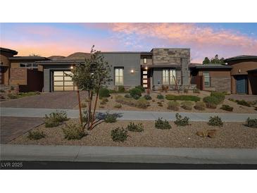 Beautiful modern home with landscaped front yard and neutral colored exterior, complemented by a driveway and two-car garage at 9938 Regency Canyon Way, Las Vegas, NV 89148