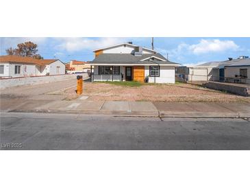 Charming two-story home featuring a wood-clad facade and desert landscaping at 116 W Victory Rd, Henderson, NV 89015