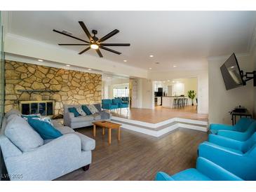 Bright living room with a stone fireplace, ceiling fan, and comfortable seating arrangement at 1601 Becke Cir, Las Vegas, NV 89104