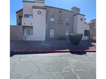 Condominium complex featuring stucco facade, manicured landscaping, and clearly marked unit numbers for easy identification at 2967 Juniper Hills Blvd # 104, Las Vegas, NV 89142