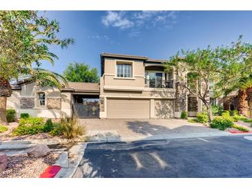 Attractive two-story house featuring a three-car garage, front yard, and beautiful landscaping at 7210 El Malpais St, Las Vegas, NV 89118