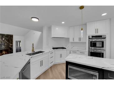 Bright kitchen features white cabinets, stainless steel appliances, and quartz countertops at 7368 Mission Hills Dr, Las Vegas, NV 89113