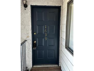 A dark painted front door with the house numbers in a gold paint at 1639 Justin Cir # 1639, Henderson, NV 89011