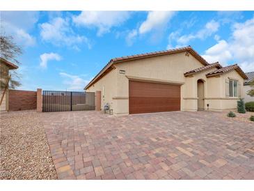 Charming single-story home with a brick driveway, two car garage, and private backyard gate at 3018 Carothers Ct, North Las Vegas, NV 89032