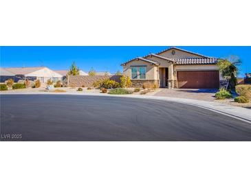 Beautiful single-story home with a two-car garage and well-manicured landscaping on a sunny day at 5648 Vermillion Ridge St, North Las Vegas, NV 89031