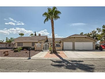 Charming single-story home with a well-manicured lawn, a palm tree, and a two-car garage at 5775 W Desert Inn Rd, Las Vegas, NV 89146