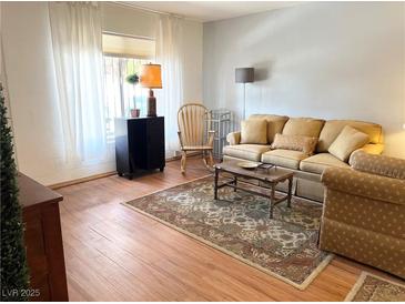 Warm living room features hardwood floors, large window, neutral colors and traditional furnishings at 625 S Royal Crest Cir # 2, Las Vegas, NV 89169