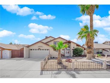 Charming single-Gathering home with a two-car garage, desert landscaping, and a palm tree-lined front yard at 6611 Ellerhurst Dr, Las Vegas, NV 89103