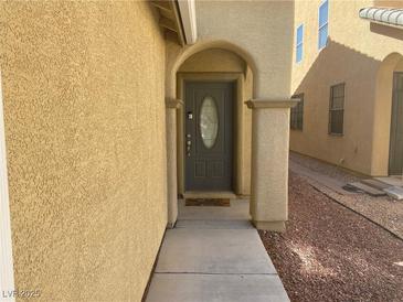 Inviting front entrance with an arched doorway and stylish gray door at 8329 Brilliant Ruby Ct, Las Vegas, NV 89139