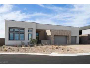 Modern home featuring stone accents, a two-car garage, and desert landscaping at 10921 Rossa Peak Ave, Las Vegas, NV 89135