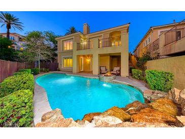 Inviting backyard pool with a rock waterfall feature and cozy seating area, perfect for relaxation and outdoor entertaining at 2 Cerchio Centrale, Henderson, NV 89011