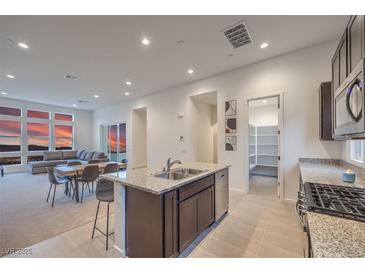 Modern kitchen features granite countertops, stainless steel appliances, and an open layout, perfect for entertaining at 3346 Esker Ridge Ave, Henderson, NV 89044