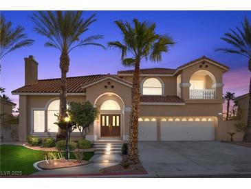 Inviting two-story home with arched entry, tile roof, and a well-manicured lawn at 4024 Mansion Hall Ct, Las Vegas, NV 89129