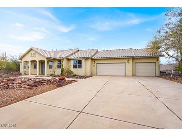 Charming single-story home with a three-car garage, tile roof, and desert landscaping at 822 Fairview Dr, Henderson, NV 89015