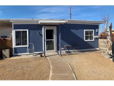Charming single-story home with blue wood siding, trimmed windows, and cozy chairs on the front walkway at 11 Magnesium St, Henderson, NV 89015