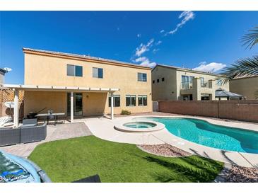 Backyard with a pool and spa, including a covered patio and artificial turf at 1609 Danielle Rebecca Ave, North Las Vegas, NV 89086
