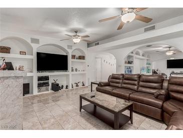 Bright living room with a large leather couch, tile floors, and recessed shelving at 1924 S 6Th St, Las Vegas, NV 89104