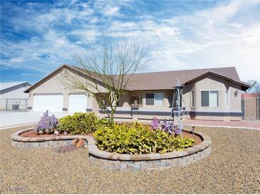 Charming single-story home boasts desert landscaping and a two-car garage under a bright blue sky at 340 Domingo St, Pahrump, NV 89048