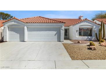 Charming single-story home with a two-car garage, desert landscaping, and a red tile roof at 4032 Bola Dr, North Las Vegas, NV 89032