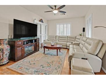 Comfortable living room featuring a neutral color palette, large screen TV, and modern ceiling fan at 4615 Puglia Ln # 201, North Las Vegas, NV 89084