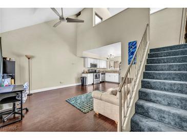 Bright living room with vaulted ceilings, ceiling fan, wood floors and open to the kitchen at 5157 Garden Ln # F, Las Vegas, NV 89119