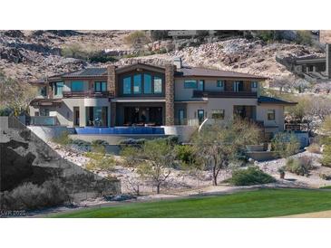 Stunning multi-story home featuring a pool, balconies and desert landscaping at 64 Promontory Ridge Dr, Las Vegas, NV 89135