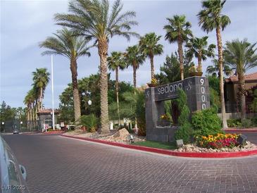 Community entrance featuring lush landscaping, mature palms, and a stately monument sign at Sedona on the Boulevard at 9000 Las Vegas Blvd # 2220, Las Vegas, NV 89123
