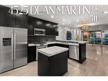 Modern kitchen featuring stainless steel appliances, a center island, and sleek black cabinetry at 4525 Dean Martin Dr # 511, Las Vegas, NV 89103